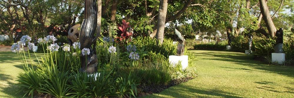 Shona Sculpture Gallery - Zimbabwean stone sculptures displayed in a lush garden