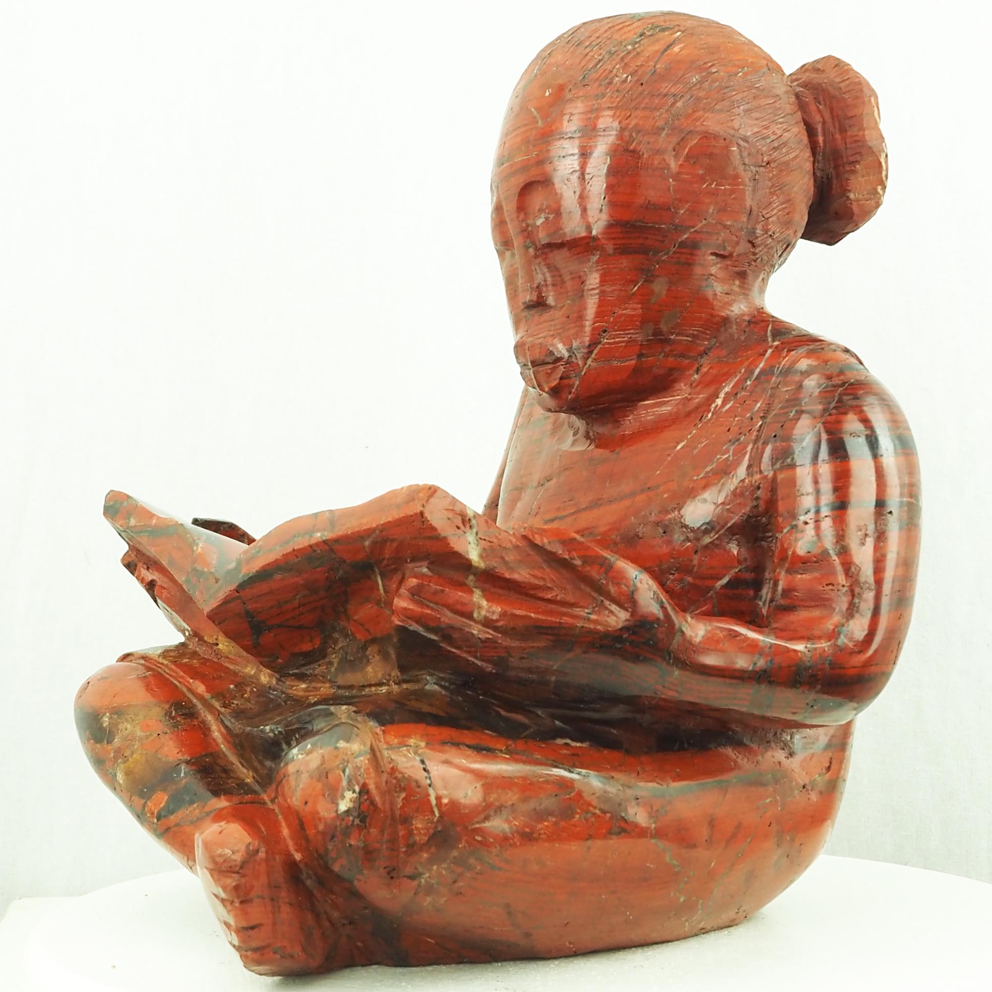 Sculpture child girl reading red stone - Doing My Homework by Jonathan Mhondorohuma - front right